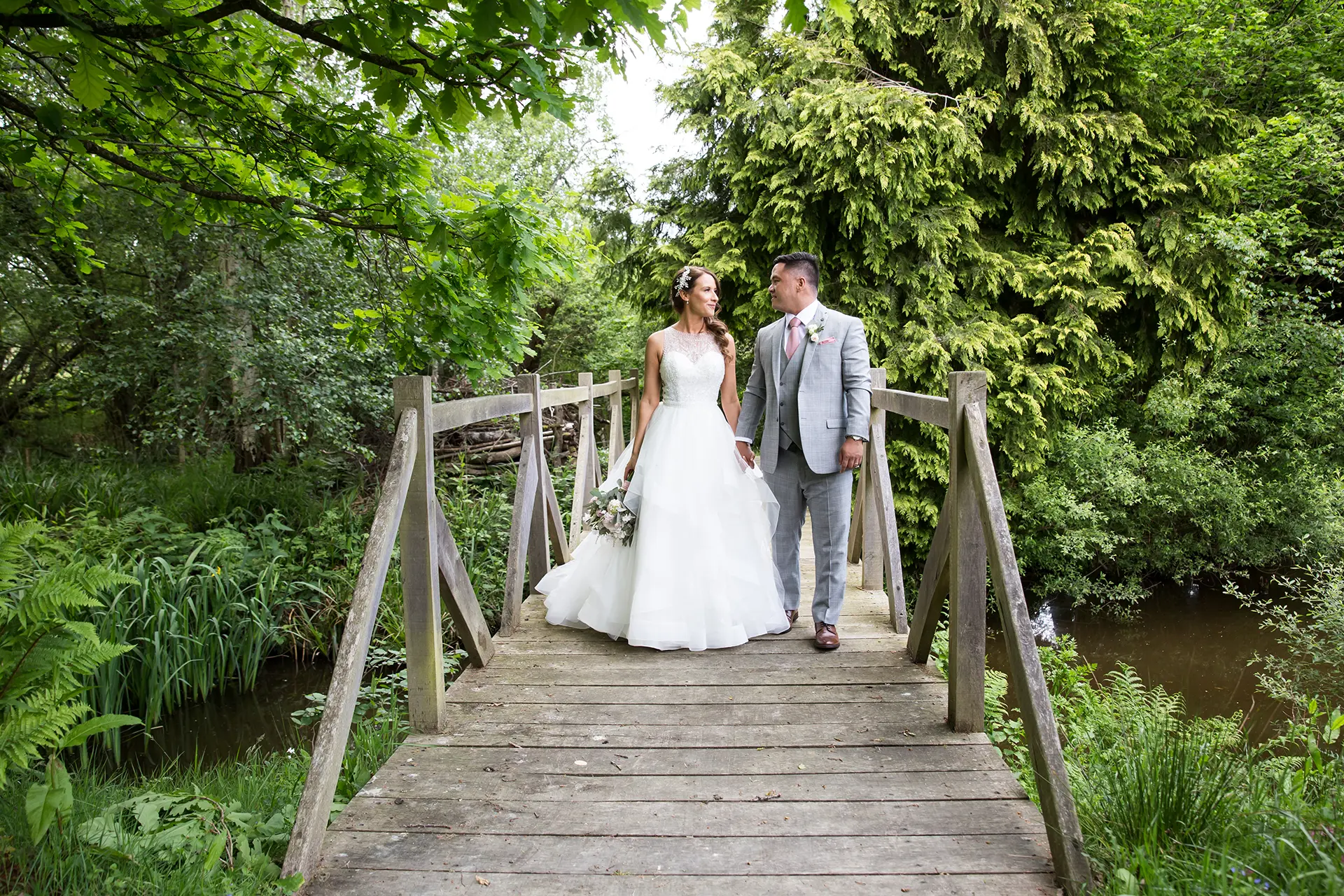 bride and groom on the bridge at Brookfield Barn